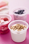 Assorted yoghurts with cereals, berries and melon