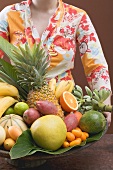 Woman holding bowl of exotic fruit