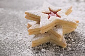 Three jam biscuits with icing sugar, in a pile