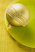 Gold Christmas tree bauble on green plate