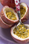 Purple passion fruits, halved, with spoon