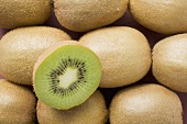 Half a kiwi fruit on several whole kiwi fruits