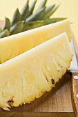 Wedges of pineapple on chopping board
