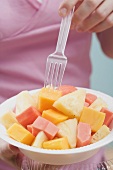 Woman eating exotic fruit salad