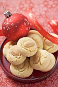 Almond biscuits on plate with Christmas bauble and ribbon