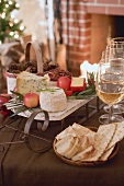Cheese board, crackers & white wine in front of fireplace (Xmas)