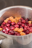 Cranberrysauce zubereiten: Cranberries mit Orangen im Topf