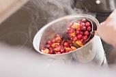 Making cranberry sauce: boiling cranberries and oranges