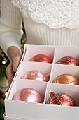 Woman holding box of Christmas baubles