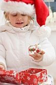Kleines Mädchen freut sich über Weihnachtsgeschenk