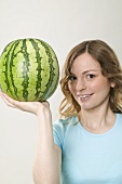 Woman holding watermelon on one hand