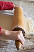 Child's hands rolling out biscuit dough