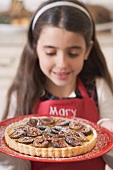 Girl holding freshly-baked fig tart