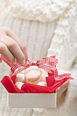 Woman holding box of Christmas biscuits
