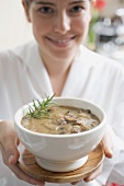 Young woman holding mushroom soup