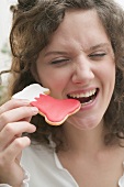 Woman biting Christmas biscuit (red boot)