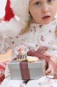 Small girl holding Christmas gifts
