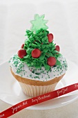 Cupcake, weihnachtlich verziert, auf Teller mit Schleife