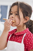 Small girl eating home-made Christmas biscuit