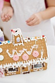 Child decorating gingerbread house