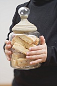 Child holding storage jar full of shortbread