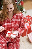 Frau öffnet Weihnachtspäckchen