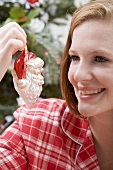 Woman holding Christmas tree ornament (Father Christmas)