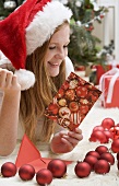 Woman in Father Christmas hat reading Christmas card