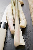 Young ginger on chopping board with Asian knife