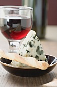 Piece of blue cheese, savoury stick and glass of red wine