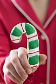 Hand holding candy cane biscuit