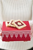 Woman holding jam biscuits on red box