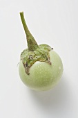 A green mini-aubergine with drops of water