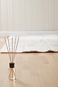 Incense sticks and mat on parquet floor