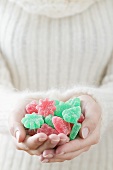 Woman holding sugar-coated jelly sweets (Christmas)