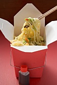 Noodles with vegetables in take-away container, soy sauce