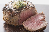 Peppered steak with herb butter, a slice cut off