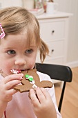 Kleines Mädchen isst Lebkuchenfigur