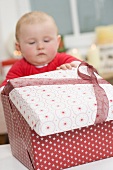 Baby opening Christmas parcel