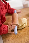 Toddler with rolling pin and ball of dough