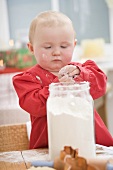 Kleinkind hält Mehl in den Händen