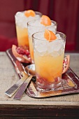Drei fruchtige Drinks mit Orangen und Granatäpfeln