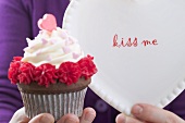 Frau hält Cupcake und Teller zum Valentinstag