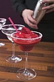 Strawberry Daiquiri in glass, bartender in background