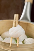 Dim sum on chopsticks and in bamboo steamer