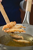 Deep-frying prawns in wok