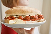 Woman serving a meatball sandwich