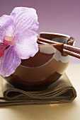 Lacquer bowl with chopsticks and orchid on cloth (Asia)