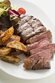 Beef steak with potato wedges and salad