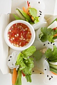 Reispapierröllchen mit Gemüse und Sauce im Take-Out-Behälter